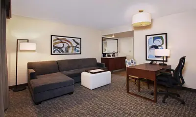 a living room with a couch and a desk at Embassy Suites by Hilton Anaheim North in Anaheim