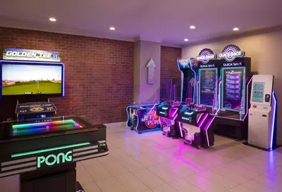 a room with arcade games and a flat screen tv at Embassy Suites by Hilton Anaheim North in Anaheim