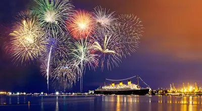 a fireworks display with a cruise ship in the water at Scottish Inns in Long Beach