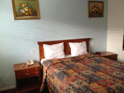 a hotel room with a bed and a telephone at Scottish Inns in Long Beach