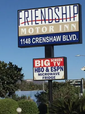 a sign for a motor inn on a street at Friendship Motor Inn in Los Angeles