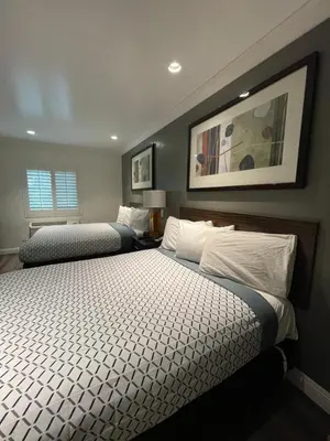 a bedroom with two beds and a picture on the wall at La Casa Inn in Pasadena