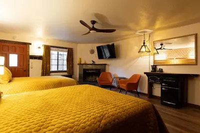 a hotel room with two beds and a tv at The Burgundy in Big Bear Lake