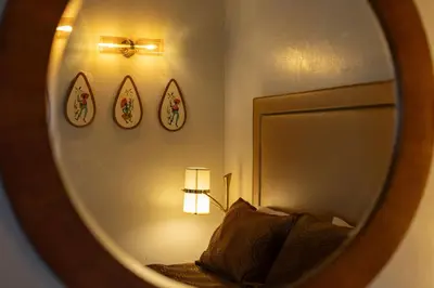 a mirror of a bedroom with a bed and a lamp at The Burgundy in Big Bear Lake