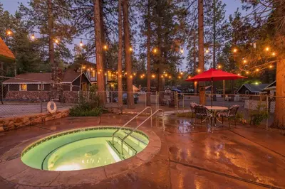 a hot tub in a patio with a table and umbrella at The Burgundy in Big Bear Lake