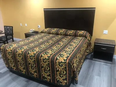 a bedroom with a bed with a patterned blanket on it at Economy Inn near Ontario Airport - Chino in Ontario
