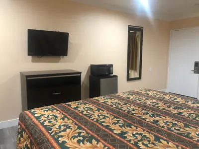 a hotel room with a bed and a flat screen tv at Economy Inn near Ontario Airport - Chino in Ontario