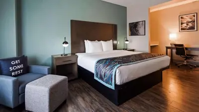 a hotel room with a bed and a chair at Best Western Plus New Barstow Inn & Suites in Barstow
