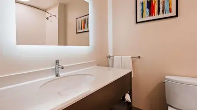 a white bathroom with a sink and a toilet at Best Western Plus New Barstow Inn & Suites in Barstow