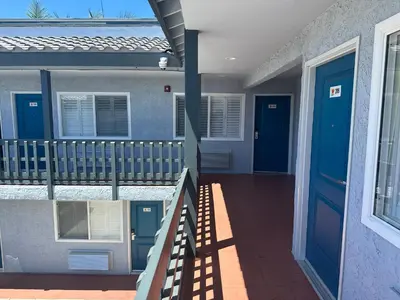 a house with a blue door and a balcony at Sahara Inn - Los Angeles in Los Angeles