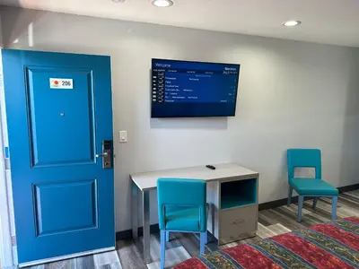 a room with a blue door and a desk and chairs at Sahara Inn - Los Angeles in Los Angeles