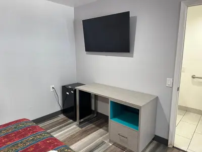 a room with a desk with a tv on the wall at Sahara Inn - Los Angeles in Los Angeles