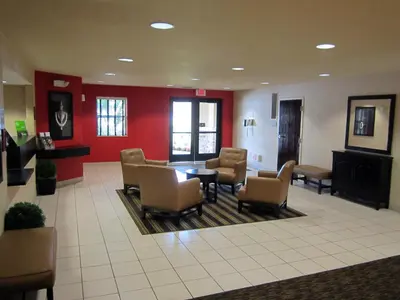 a waiting room with chairs and a table and red walls at Extended Stay America Suites - Orange County - Katella Ave in Orange