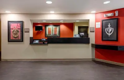 a waiting room with red walls and a mirror at Extended Stay America Suites - Orange County - Katella Ave in Orange