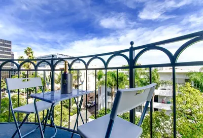 a balcony with a blue table and white chairs at Designer Penthouse 2 Bedroom with Balcony Beverly Hills Adjacent in Los Angeles