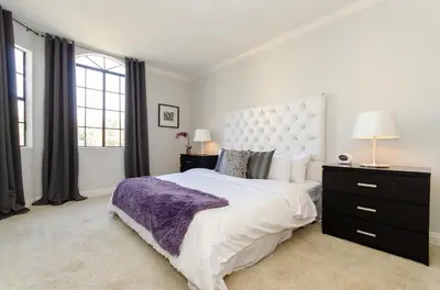 a bedroom with a large bed with a purple blanket at Designer Penthouse 2 Bedroom with Balcony Beverly Hills Adjacent in Los Angeles