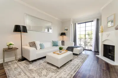 a living room with a white couch and a fireplace at Designer Penthouse 2 Bedroom with Balcony Beverly Hills Adjacent in Los Angeles