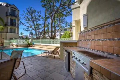 a backyard with a swimming pool and a house with a stove at Designer Penthouse 2 Bedroom with Balcony Beverly Hills Adjacent in Los Angeles