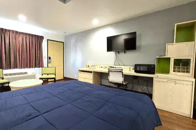 a hotel room with a bed and a desk with a computer at Century Motel Buena Park Anaheim I-5 in Buena Park