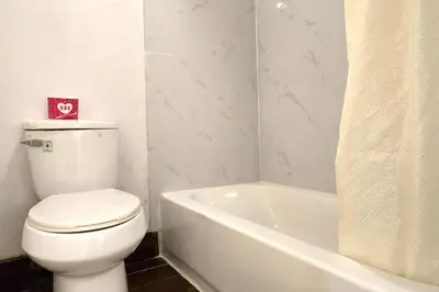 a bathroom with a white toilet and a bath tub at Century Motel Buena Park Anaheim I-5 in Buena Park