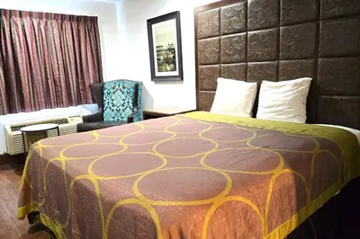 a hotel room with a bed and a chair at Century Motel Buena Park Anaheim I-5 in Buena Park