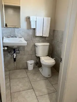 a bathroom with a toilet and a sink at Apple Valley Motel in Apple Valley