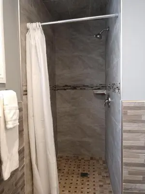 a shower with a shower curtain in a bathroom at Bartlett Motel in Lomita