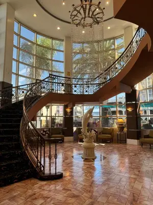 a lobby with a spiral staircase and a statue at Garden Suite Hotel and Resort in Los Angeles