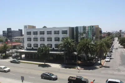 a city street with cars parked in front of a building at Garden Suite Hotel and Resort in Los Angeles
