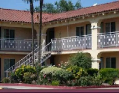 a large building with a staircase and a balcony at Golden Star Inn in San Bernardino