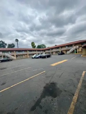 a parking lot with cars parked in front of a building at Golden Star Inn in San Bernardino