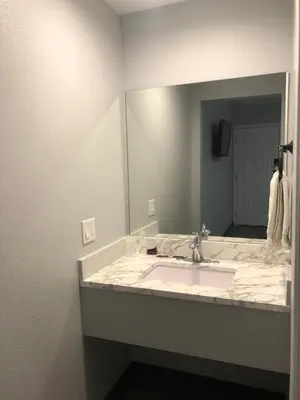 a bathroom with a sink and a large mirror at New Casa Motel Los Angeles in Los Angeles