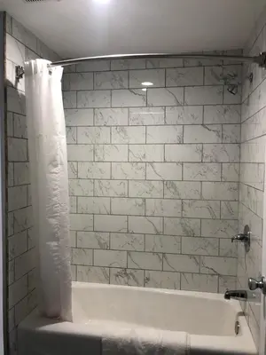 a white bath tub with a white brick wall at New Casa Motel Los Angeles in Los Angeles