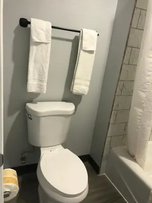 a bathroom with a white toilet and towels at New Casa Motel Los Angeles in Los Angeles