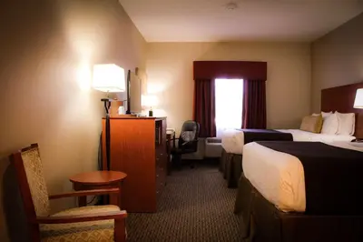 a hotel room with two beds and a desk at Best Western Plus Arrowhead Hotel in Colton