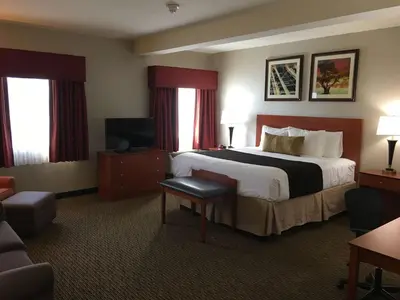 a hotel room with a bed and a television at Best Western Plus Arrowhead Hotel in Colton