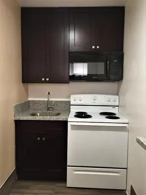 a kitchen with a white stove and a sink at Palm Inn Motel - Montclair in Montclair