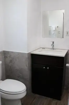 a bathroom with a white toilet and a sink at Palm Inn Motel - Montclair in Montclair