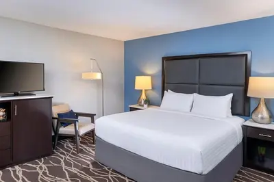 a hotel room with a large bed and a television at The Pierpont Inn in Ventura