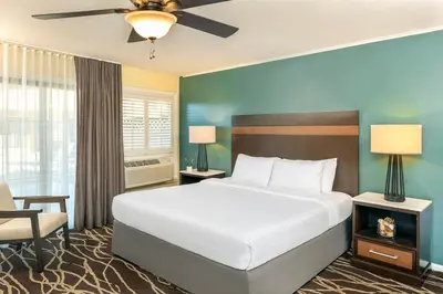 a bedroom with a large white bed and a chair at The Pierpont Inn in Ventura
