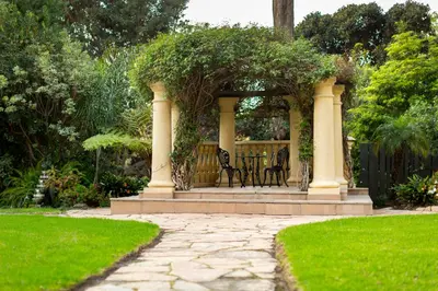 a gazebo with a table and chairs in a garden at The Pierpont Inn in Ventura