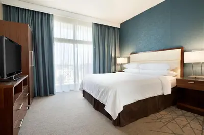 a hotel room with a bed and a television at Embassy Suites by Hilton Brea - North Orange County in Brea