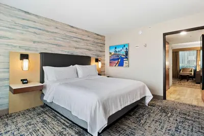 a hotel room with a large bed and a desk at Embassy Suites by Hilton Anaheim South in Anaheim