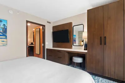 a hotel room with a bed and a desk with a television at Embassy Suites by Hilton Anaheim South in Anaheim