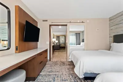 a hotel room with two beds and a flat screen tv at Embassy Suites by Hilton Anaheim South in Anaheim