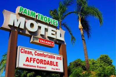 a sign for a motel with a palm tree at Palm Tropics Motel in Glendora