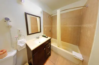a bathroom with a sink and a shower and a tub at Palm Tropics Motel in Glendora