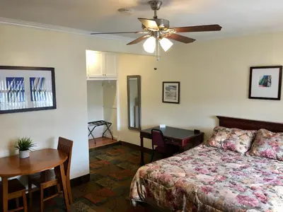 a bedroom with a bed and a table and a desk at Los Feliz Hotel in Glendale