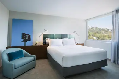 a bedroom with a bed and a chair and a window at Andaz West Hollywood, By Hyatt in Los Angeles