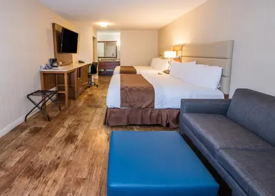a hotel room with two beds and a couch at Travelodge by Wyndham Culver City in Los Angeles